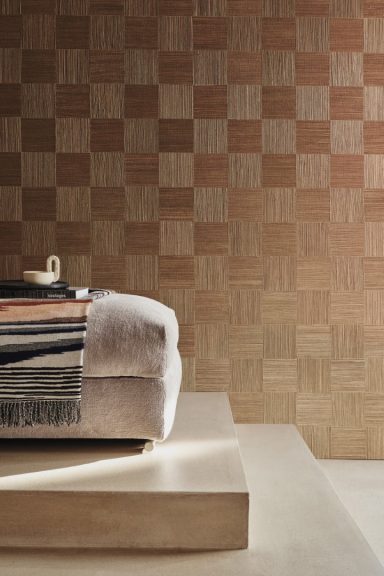 Holzplattenwand mit abgestuftem Boden und einem Bett mit gestreiftem Überwurf.